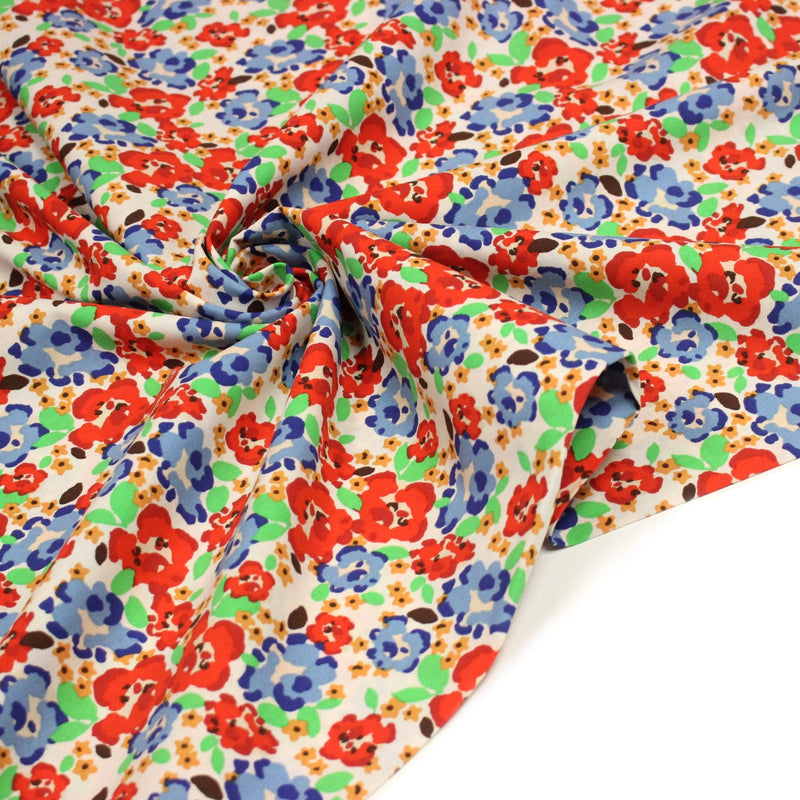 Tissu cotonnade aux fleurs graphiques rouges, bleues, vertes, fond écru - OEKO - TEX STANDARD 100 - tissuspipi.com