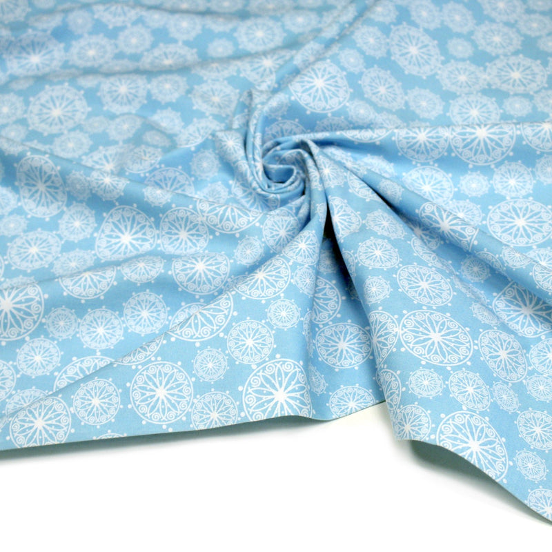 Tissu de Noël cotonnade bleu ciel aux rosaces blanches - tissuspipi.com