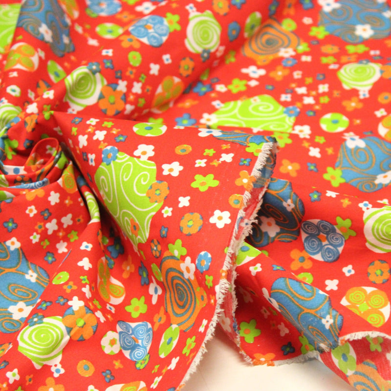 Tissu cotonnade SEVENTIES rouge et formes psychédéliques oranges, bleues, vertes - tissuspipi.com
