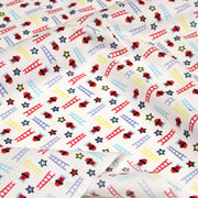 Tissu cotonnade enfant motif pompiers, échelles et étoiles multicolores sur fond blanc - tissuspipi.com