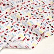 Tissu cotonnade enfant motif pompiers, échelles et étoiles multicolores sur fond blanc - tissuspipi.com