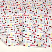 Tissu cotonnade enfant motif pompiers, échelles et étoiles multicolores sur fond blanc - tissuspipi.com
