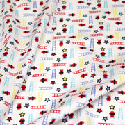 Tissu cotonnade enfant motif pompiers, échelles et étoiles multicolores sur fond blanc - tissuspipi.com