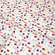 Tissu cotonnade enfant motif pompiers, échelles et étoiles multicolores sur fond blanc - tissuspipi.com