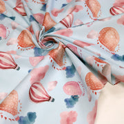 Tissu cotonnade enfant aux montgolfières roses et nuages sur fond bleu ciel - tissuspipi.com