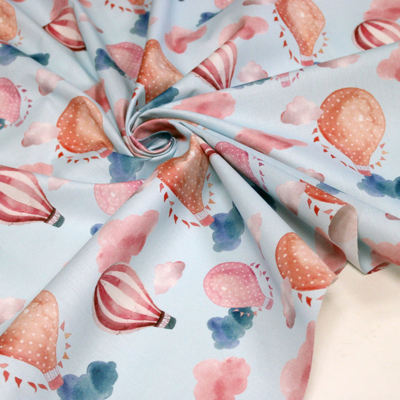 Tissu cotonnade enfant aux montgolfières roses et nuages sur fond bleu ciel - tissuspipi.com