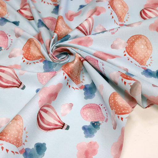 Tissu cotonnade enfant aux montgolfières roses et nuages sur fond bleu ciel - tissuspipi.com