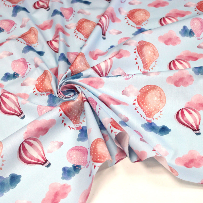 Tissu cotonnade enfant aux montgolfières roses et nuages sur fond bleu ciel - tissuspipi.com