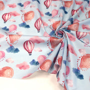 Tissu cotonnade enfant aux montgolfières roses et nuages sur fond bleu ciel - tissuspipi.com