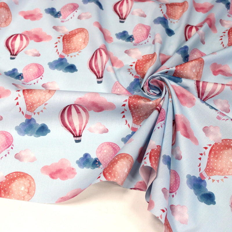 Tissu cotonnade enfant aux montgolfières roses et nuages sur fond bleu ciel - tissuspipi.com