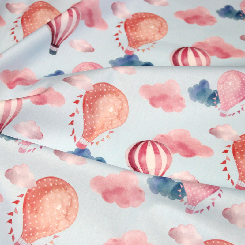 Tissu cotonnade enfant aux montgolfières roses et nuages sur fond bleu ciel - tissuspipi.com