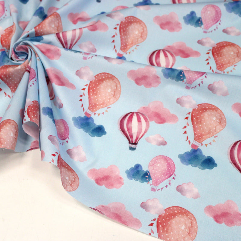 Tissu cotonnade enfant aux montgolfières roses et nuages sur fond bleu ciel - tissuspipi.com