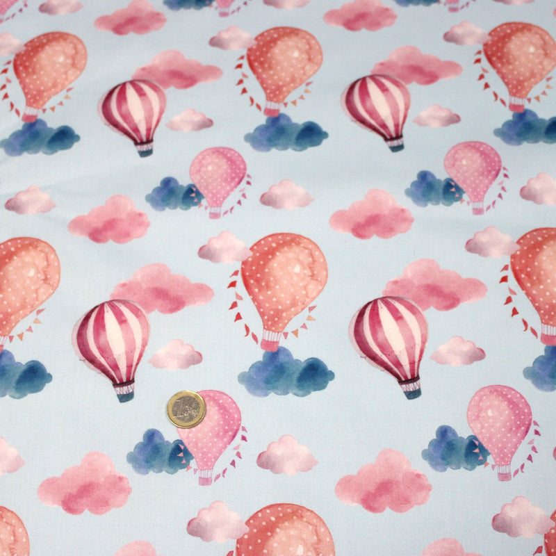 Tissu cotonnade enfant aux montgolfières roses et nuages sur fond bleu ciel - tissuspipi.com