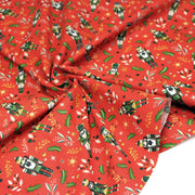 Tissu cotonnade de NOËL, Casse-noisettes, houx et feuillages ocres, fond rouge - OEKO-TEX STANDARD 100 - tissuspipi.com