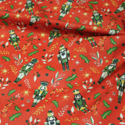 Tissu cotonnade de NOËL, Casse-noisettes, houx et feuillages ocres, fond rouge - OEKO-TEX STANDARD 100 - tissuspipi.com