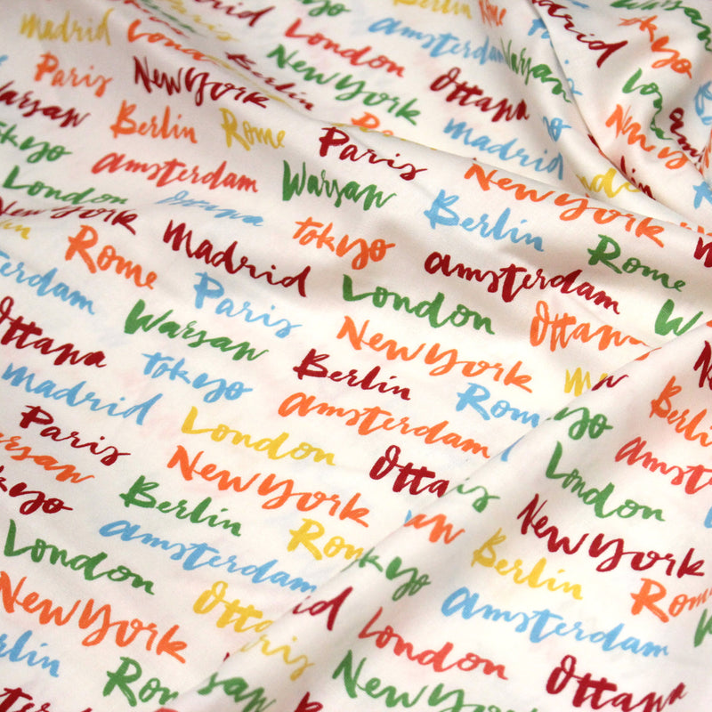 Tissu popeline coton blanc aux noms de ville multicolores, collection VOYAGE - tissuspipi.com