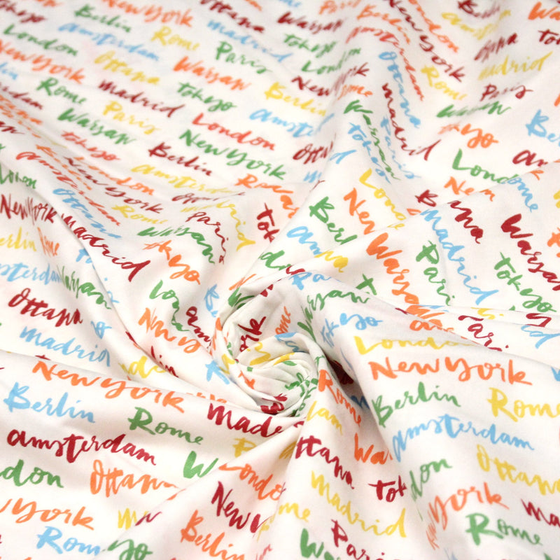 Tissu popeline coton blanc aux noms de ville multicolores, collection VOYAGE - tissuspipi.com
