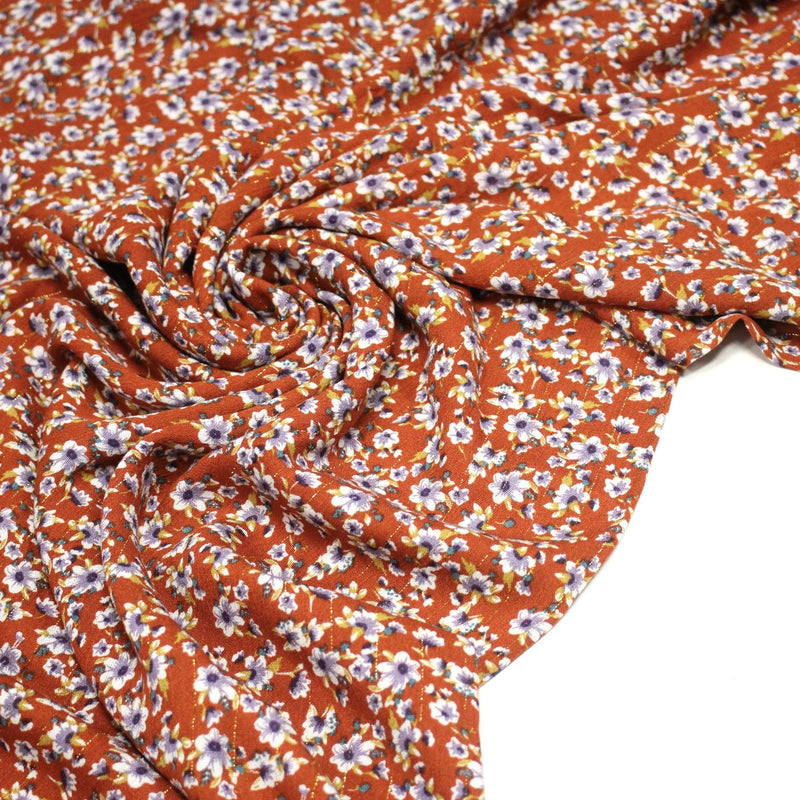 Tissu Viscose crêpe rouille, fleuri blanc & mauve et liserés lurex dorés - tissuspipi.com