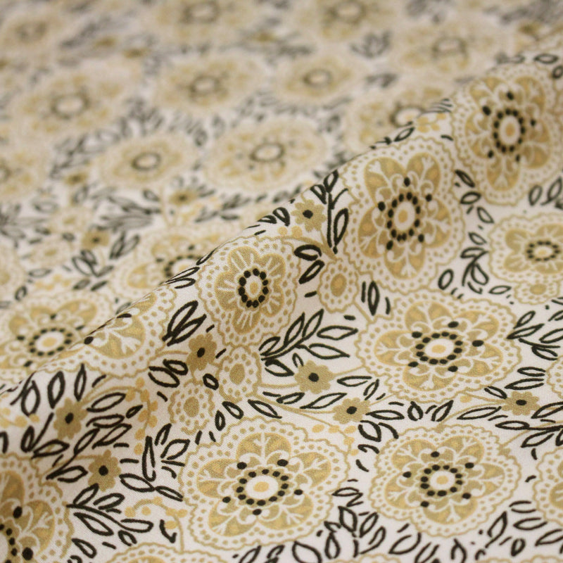 Tissu popeline coton ocre clair aux fleurs & fines arabesques noirs et jaunes - tissuspipi.com