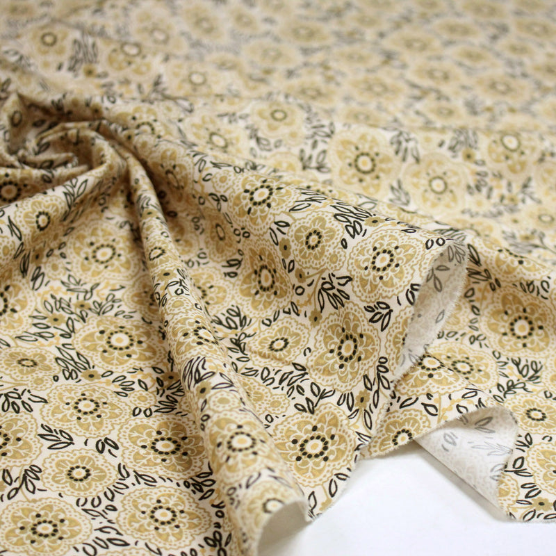 Tissu popeline coton ocre clair aux fleurs & fines arabesques noirs et jaunes - tissuspipi.com