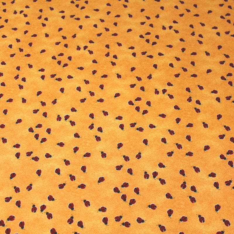 Tissu popeline de coton aux petites coccinelles rouges, fond jaune safran - tissuspipi.com