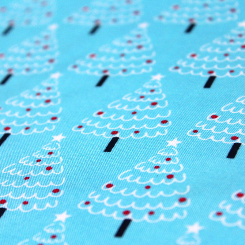 Tissu popeline de coton de Noël aux sapins blancs & rouges, fond bleu - tissuspipi.com