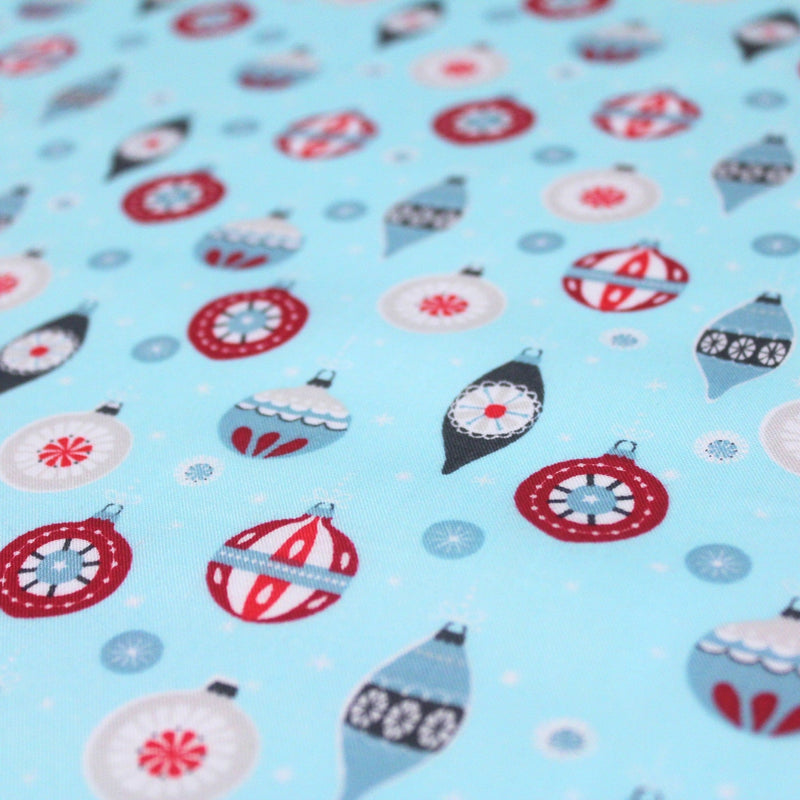 Tissu popeline de coton de Noël aux boules de Noël, fond bleu ciel - tissuspipi.com