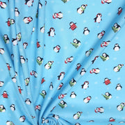 Tissu popeline de coton de Noël aux pingouins de Noël, fond bleu ciel - tissuspipi.com