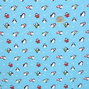 Tissu popeline de coton de Noël aux pingouins de Noël, fond bleu ciel - tissuspipi.com