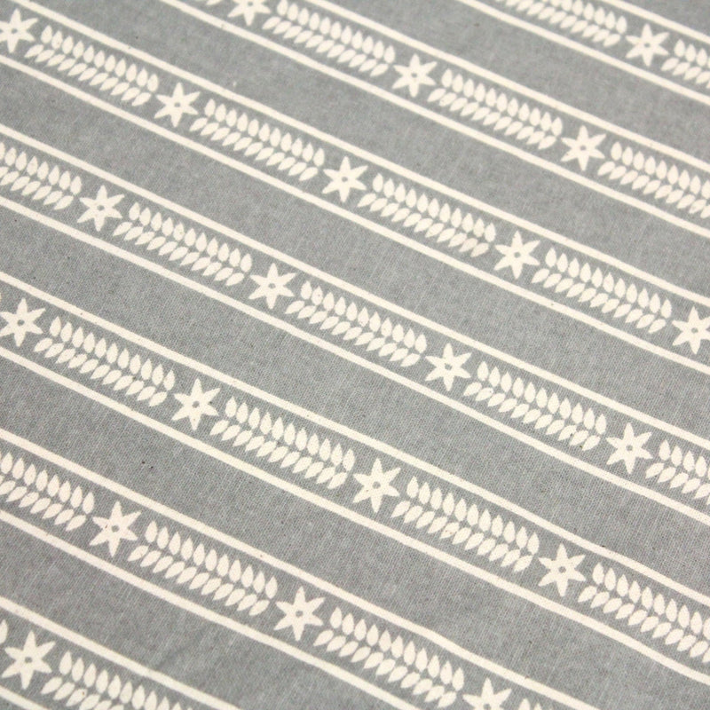 Tissu de coton de Noël scandinave aux étoiles de neiges écrues, fond gris - tissuspipi.com