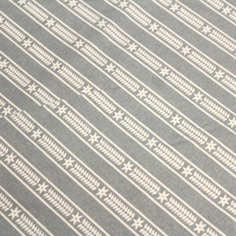 Tissu de coton de Noël scandinave aux étoiles de neiges écrues, fond gris - tissuspipi.com