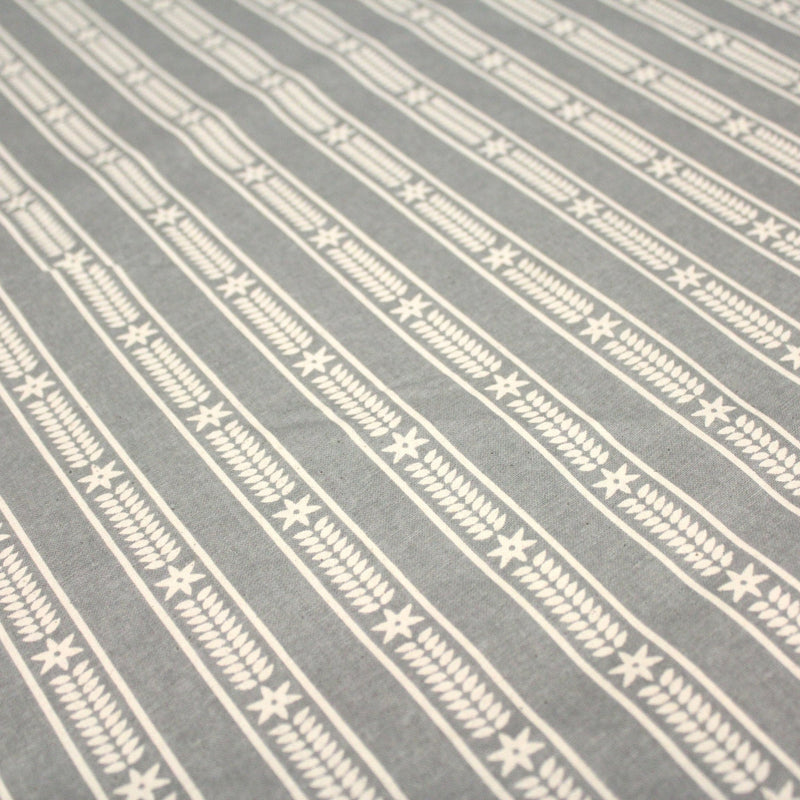 Tissu de coton de Noël scandinave aux étoiles de neiges écrues, fond gris - tissuspipi.com