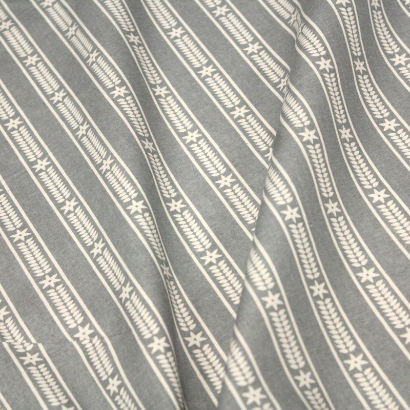 Tissu de coton de Noël scandinave aux étoiles de neiges écrues, fond gris - tissuspipi.com